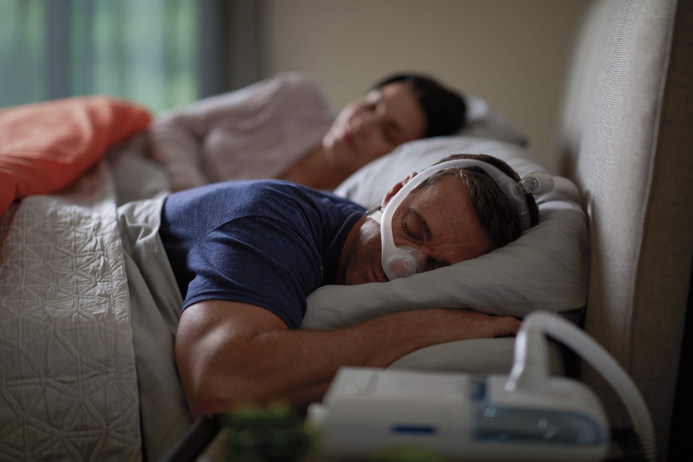 CPAPマスクを装着して安らかに眠る男性